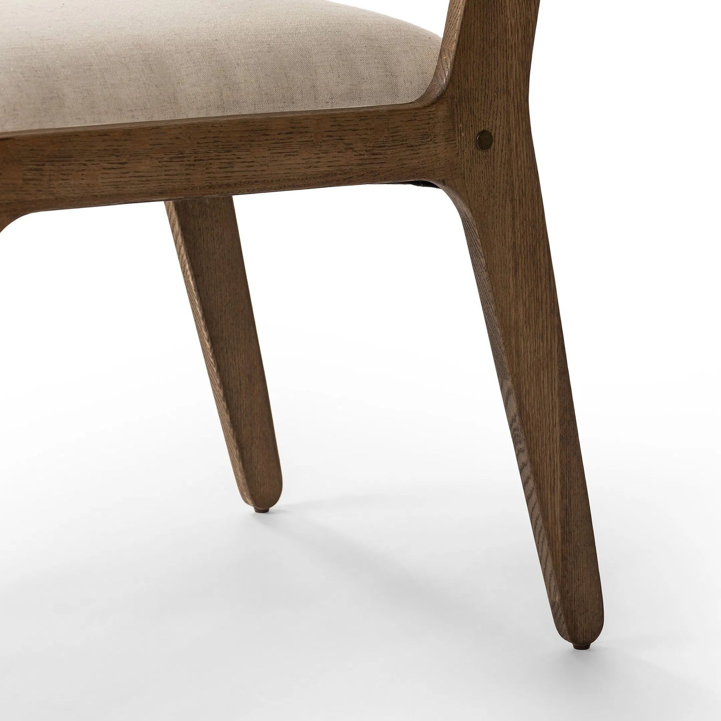 007 SI-2320196 | Closeup | Norwalk Dining Chair by Four Hands in savile flax, lamont oak, antique brass. Made from 92% polyester, 8% flax/linen, solid oak, stainless steel in a unique style.