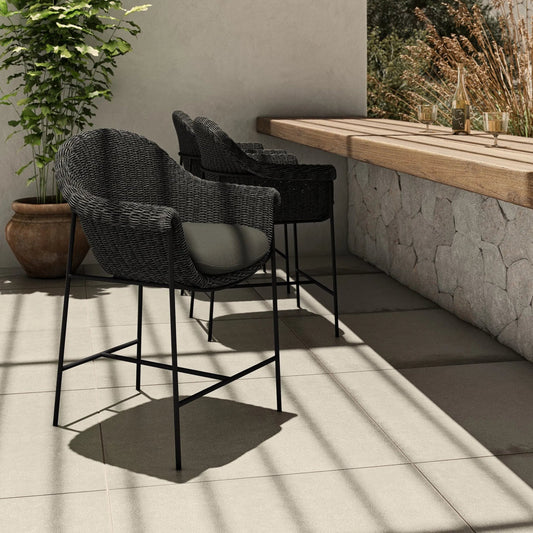 Suerte Outdoor Counter Stool by Four Hands in arashi ink, charcoal iron, faux black hyacinth. Made from 100% acrylic, iron, 100% polyethylene in a rustic style.