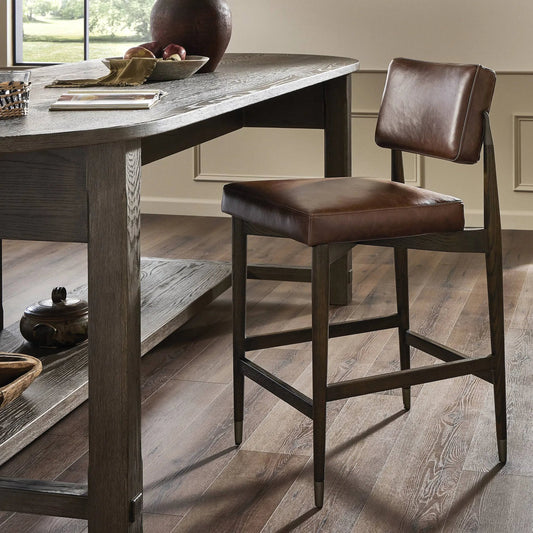 Anton Counter Stool by Four Hands in havana brown, burnt oak, raw iron. Made from top grain leather, solid oak, iron in a modern style.