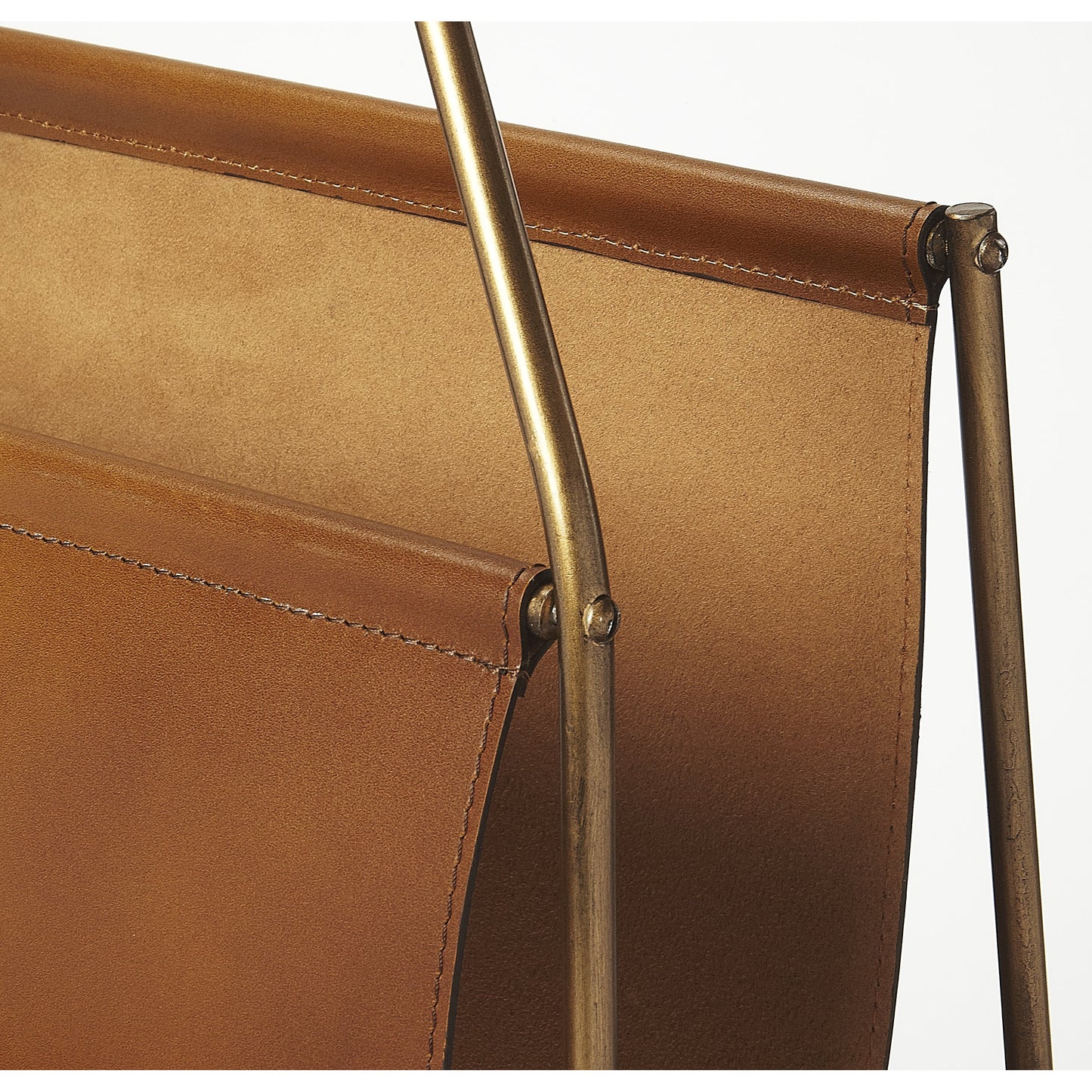 006 S-346370 | Closeup | Rupert Leather Magazine Basket by Butler Specialty Company in medium brown and brown leather. Made from iron (antique brass finish), leather, polysuede interior in a rustic style.