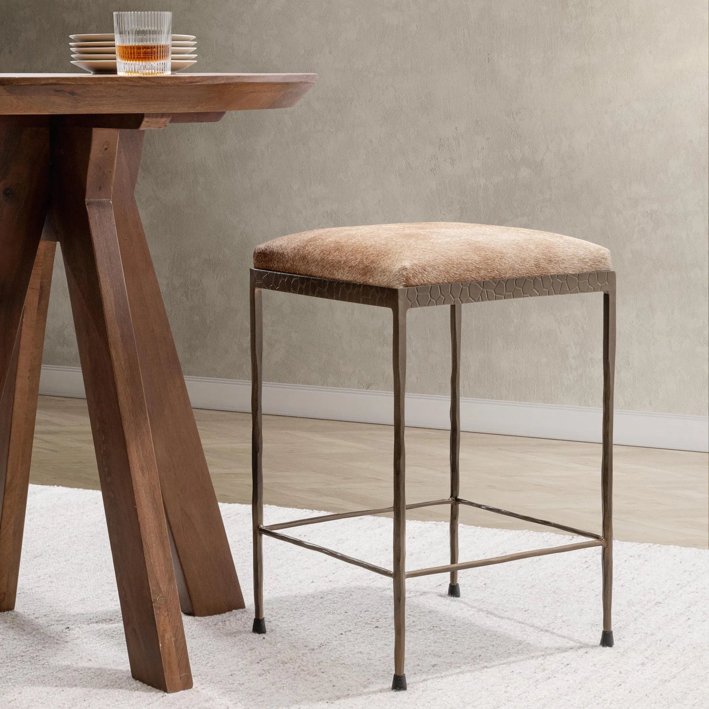 027 SI-2256335 | Lifestyle | Bose Hide Leather Counter Stool by Classic Home. Made from embossed hammered iron, hair on hide in a modern style.