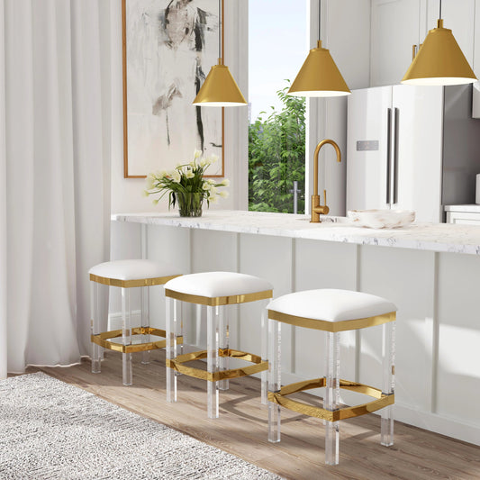 Jordan Counter Stool by Butler Specialty Company in white and polished gold. Made from stainless steel, high polished gold finish, acrylic, mdf, fabric, faux leather, polyvinyl, polyurethane foam core: seat height, 24" in a tran