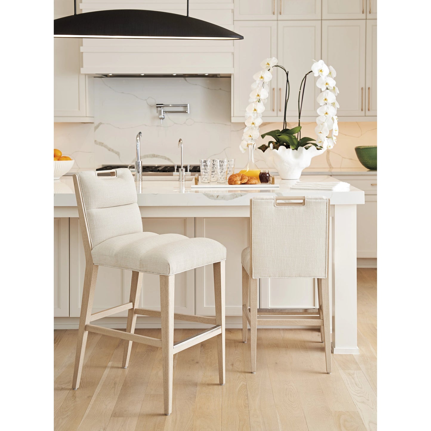 003 SI-2136898 | Lifestyle | Greer Channeled Upholstered Bar Stool by Tommy Bahama Home in sand drift. Made from unique in a modern style.