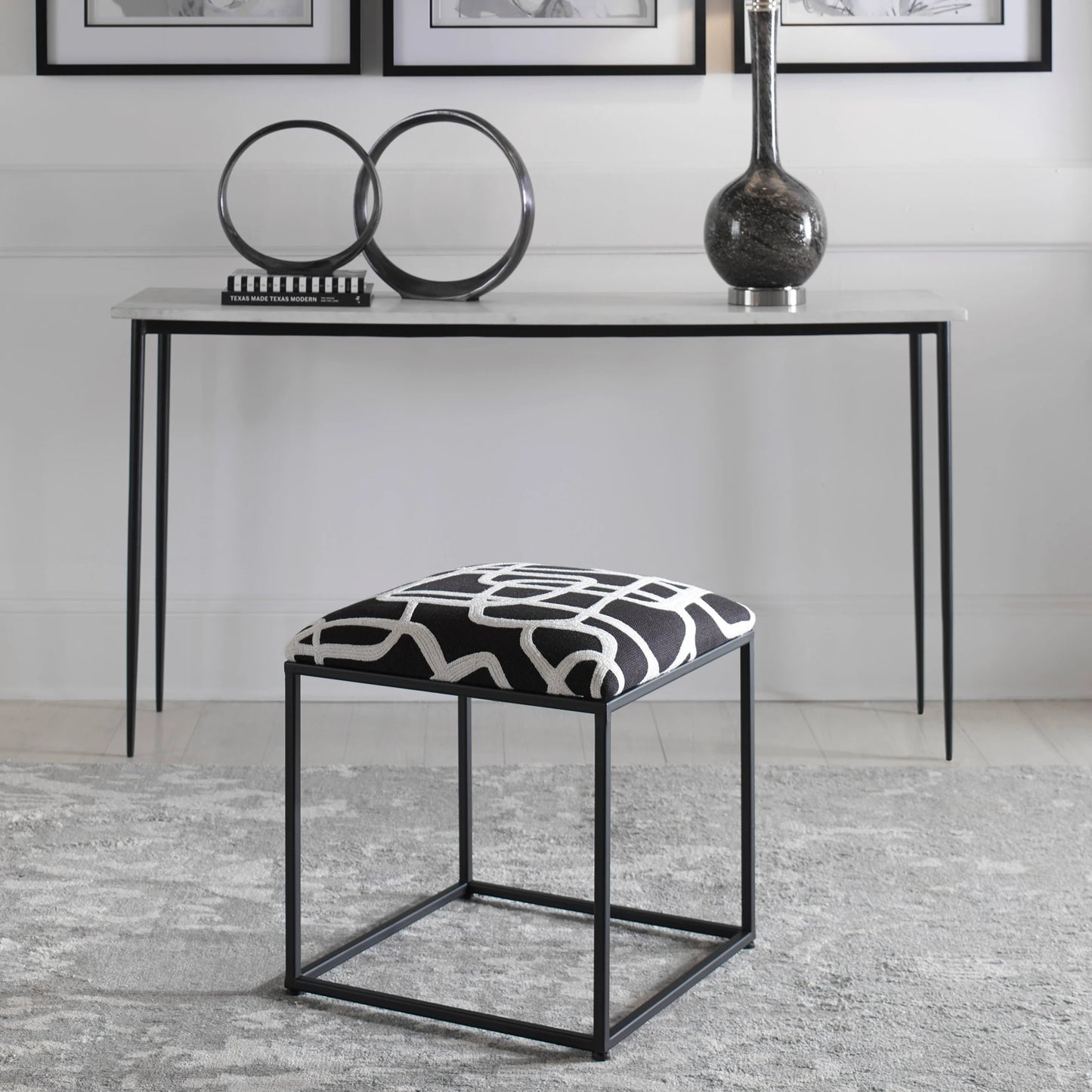 004 SI-1923676 | Lifestyle | Twists and Turns Accent Stool by Uttermost in matte black. Made from iron, mdf, foam, polyester in a modern style.