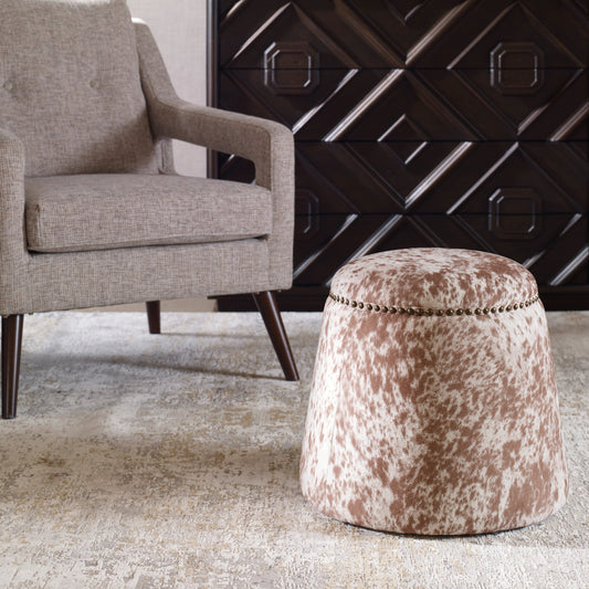 Gumdrop Cow Hide Ottoman by Uttermost in chestnut, white and brass. Made from plywood, foam, fabric in a rustic style.