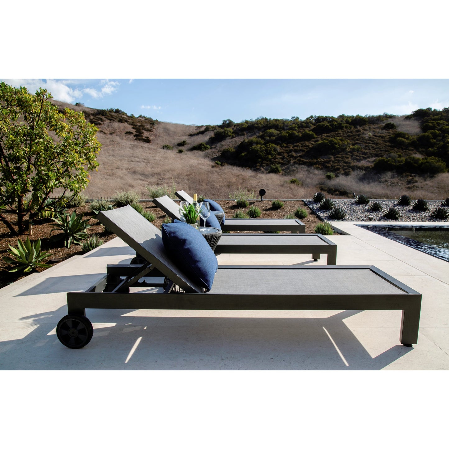 005 SI-2166977 | Lifestyle | Redondo Outdoor Adjustable Sling Chaise by Sunset West in slate. Made from aluminum in a modern style.