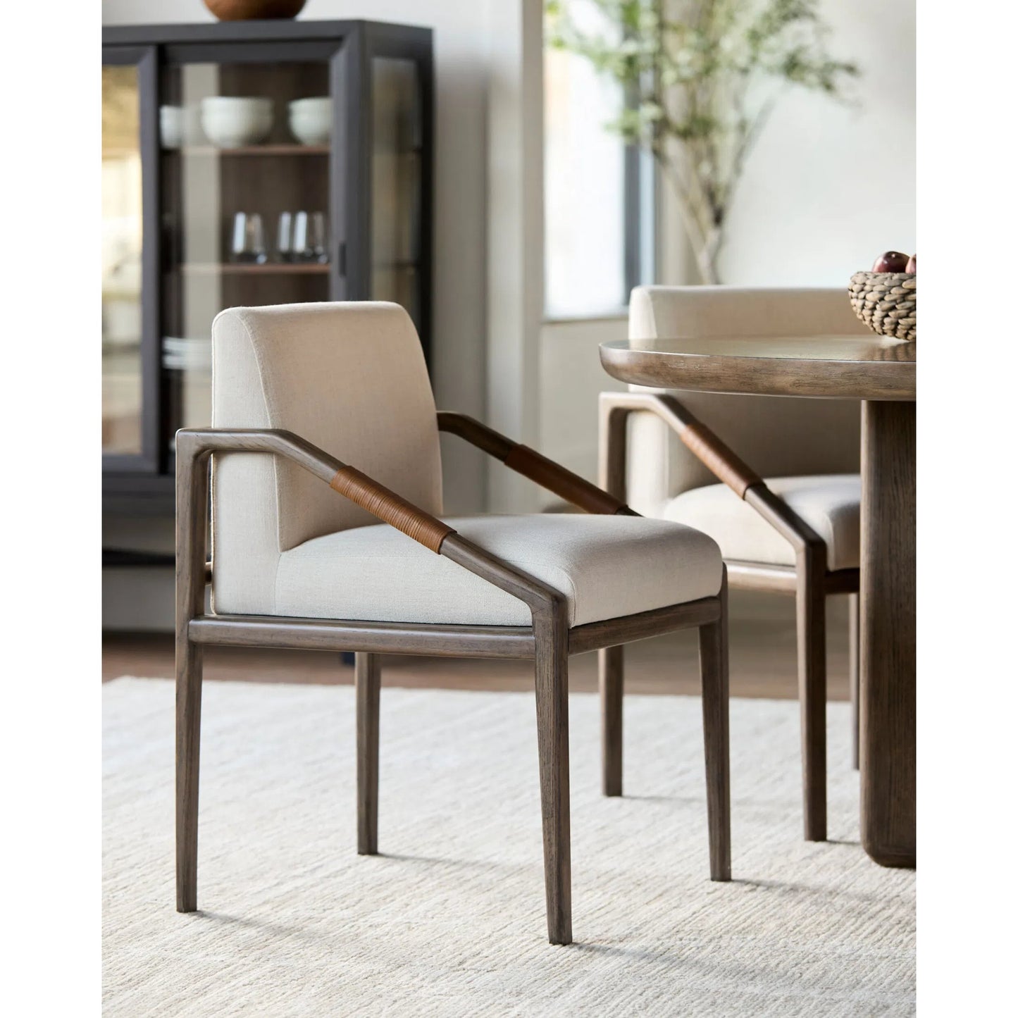 004 SI-2379484 | Lifestyle | Atra Dining Chair by Becki Owens x Surya in light beige, brown. Made from polyester, linen, red oak, leather wrapped, polyester wrapped foam in a rustic style.