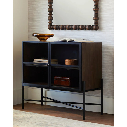 Mariposa Cabinet by Becki Owens x Livabliss in top: dark brown, clear, black; base: black and powder coated. Made from mango wood, glass, iron in a modern style.