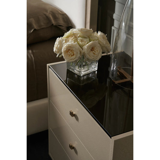 Iliad Nightstand by Caracole in ivory, smoked, bronze, gold and ivory craze, brushed gold paint. Made from poplar, koto, glass in a modern style.