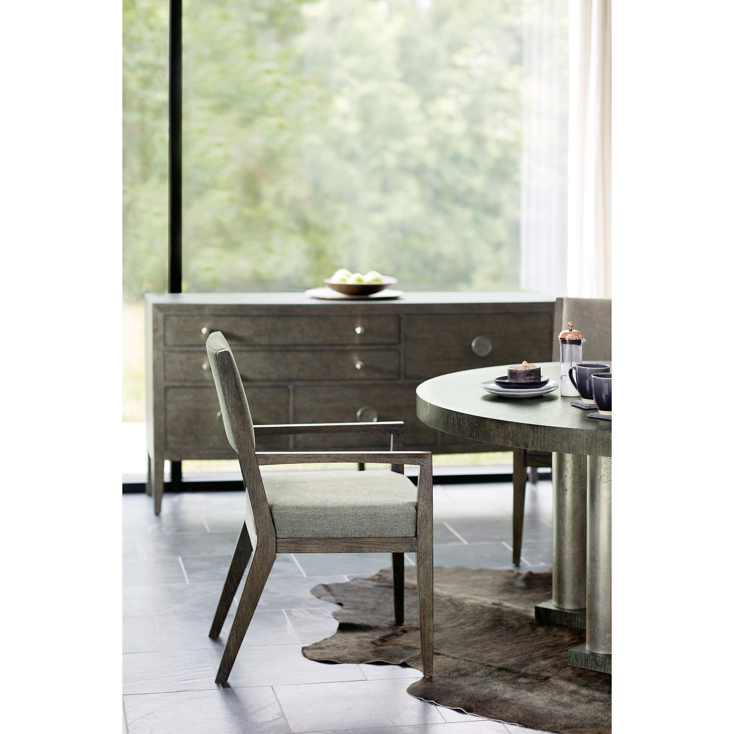 006 SI-1711408 | Lifestyle | Linea Round Dining Table by Bernhardt in cerused charcoal, textured graphite metal. Made from white oak veneers, cast aluminum in a unique style.