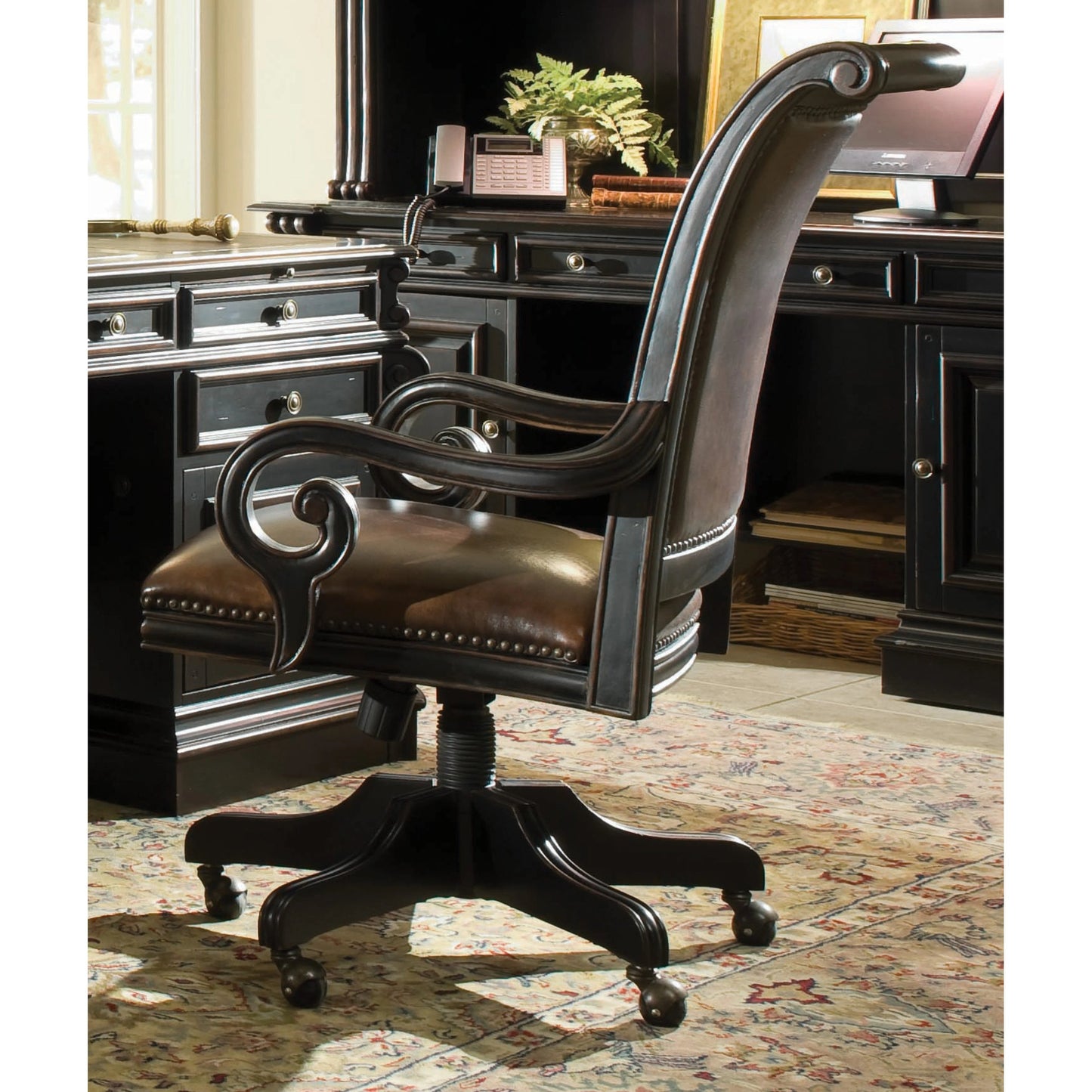 006 SI-1749887 | Lifestyle | Telluride Tilt Swivel Chair by Hooker Furniture in brown. Made from cherry veneers with carved leather (aniline plus pigment), nailhead trim in a traditional style.