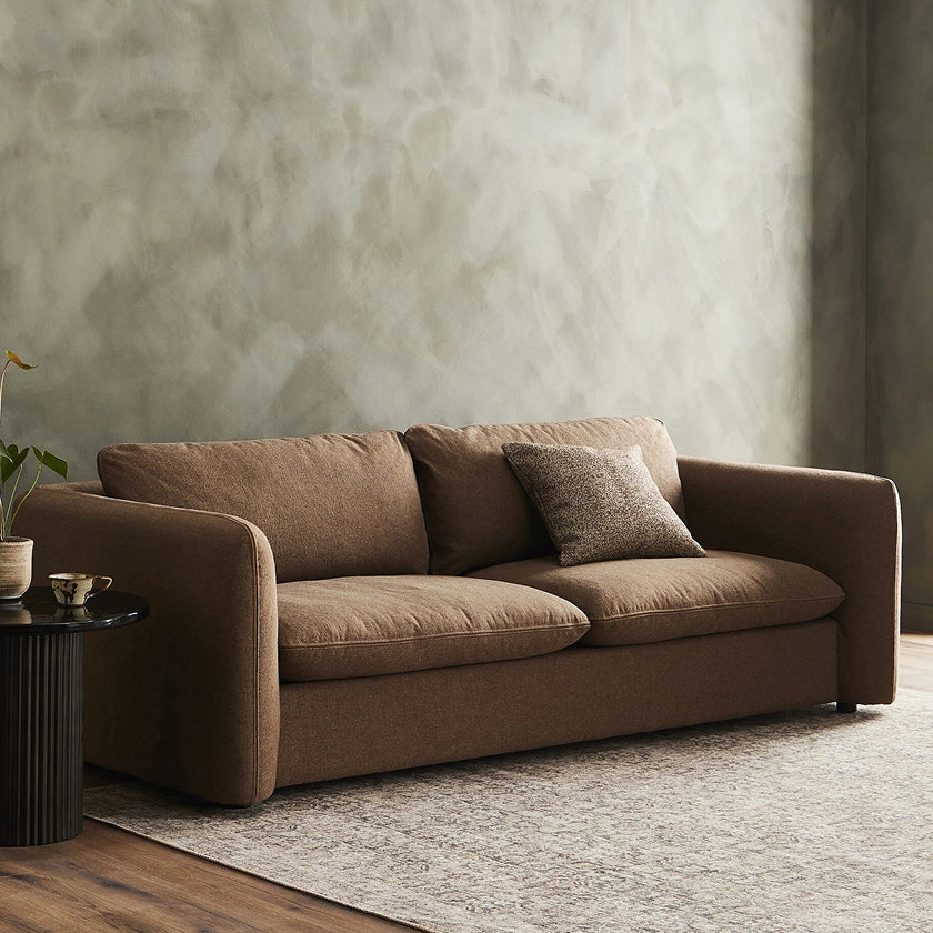 Contemporary brown sofa with plush cushions and a minimalist design, perfect for adding comfort and style to modern living rooms.