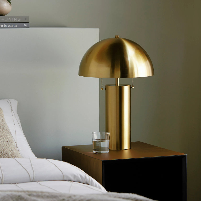 Modern brass table lamp with a sleek dome shade, perfect for adding a stylish and sophisticated touch to bedside tables and contemporary bedrooms.