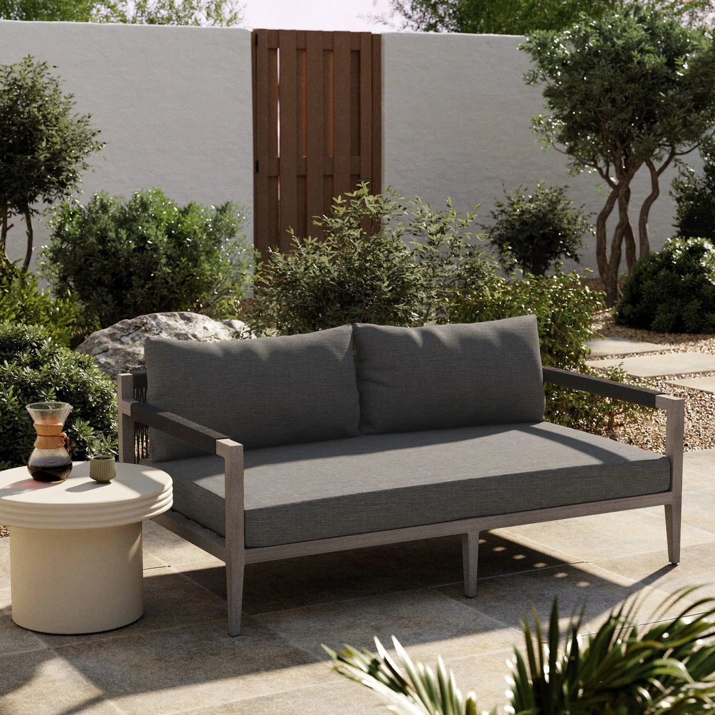029 SR-712993 | Lifestyle | Sherwood Outdoor Sofa, Weathered Grey by Four Hands. Made from 100% olefin, solid fsc®-certified teak, 100% polypropylene in a coastal style.