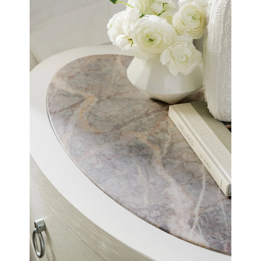 Serenity Wavecrest Oval Nightstand by Hooker Furniture in shell, champagne. Made from oak veneers, honed marble veneers with slight sandblasting in a modern style.