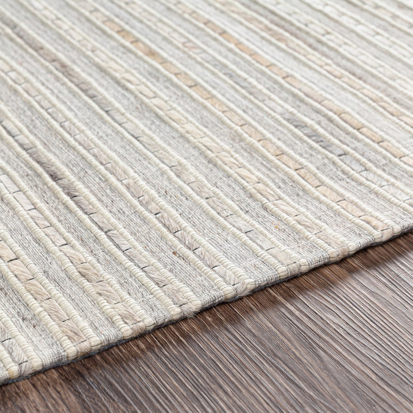 005 SI-1886215,SI-1886217,SI-1886218 | Closeup | Medora Rug - 26072 by Surya in taupe, dark brown, oatmeal, black, medium gray. Made from 50% wool, 30% hair on hide, 20% viscose in a unique style.