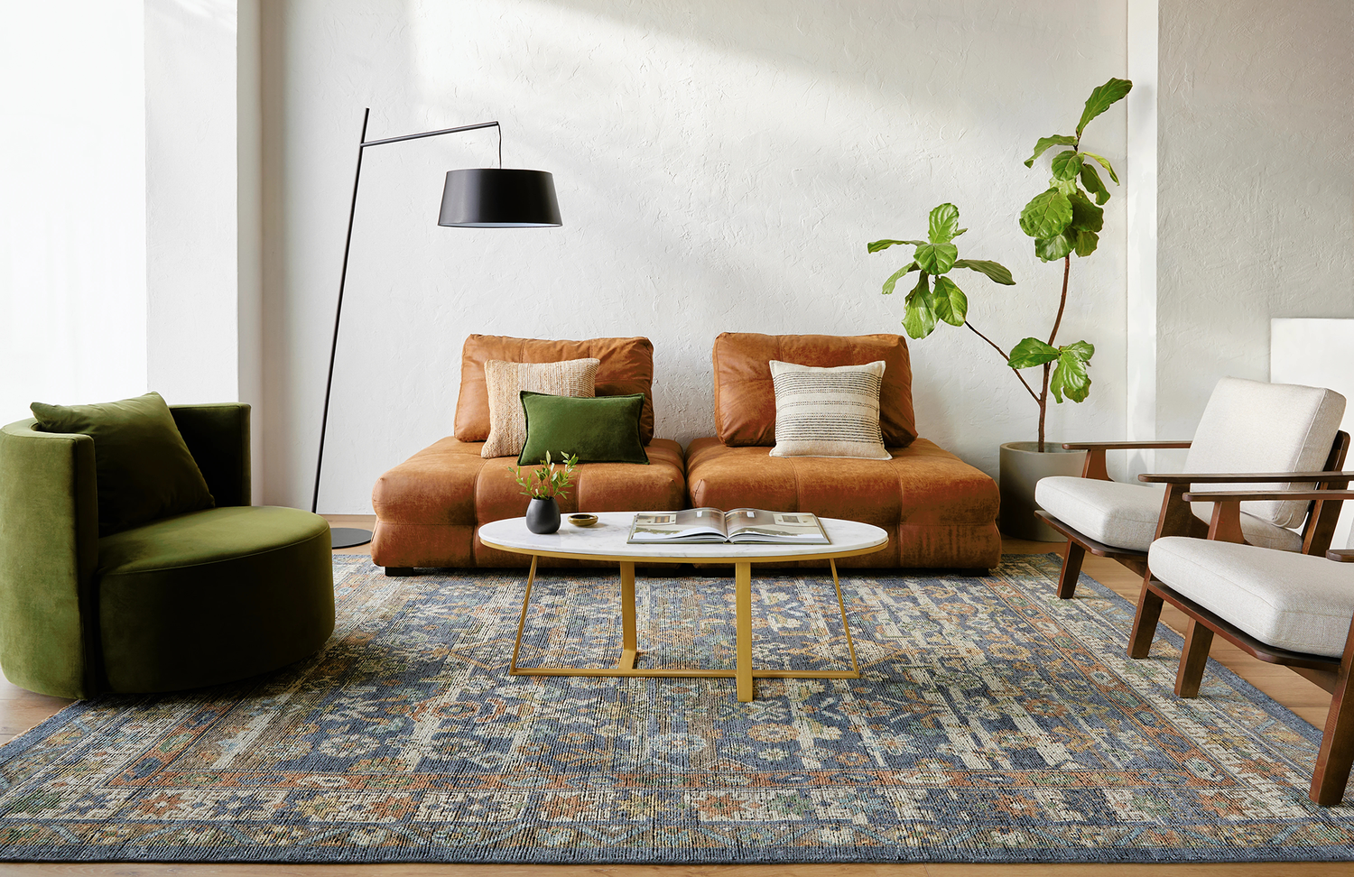 Bright and modern living room featuring a rust-colored sofa, green accent chair, marble coffee table, and a blue patterned area rug, creating a fresh and vibrant atmosphere.
