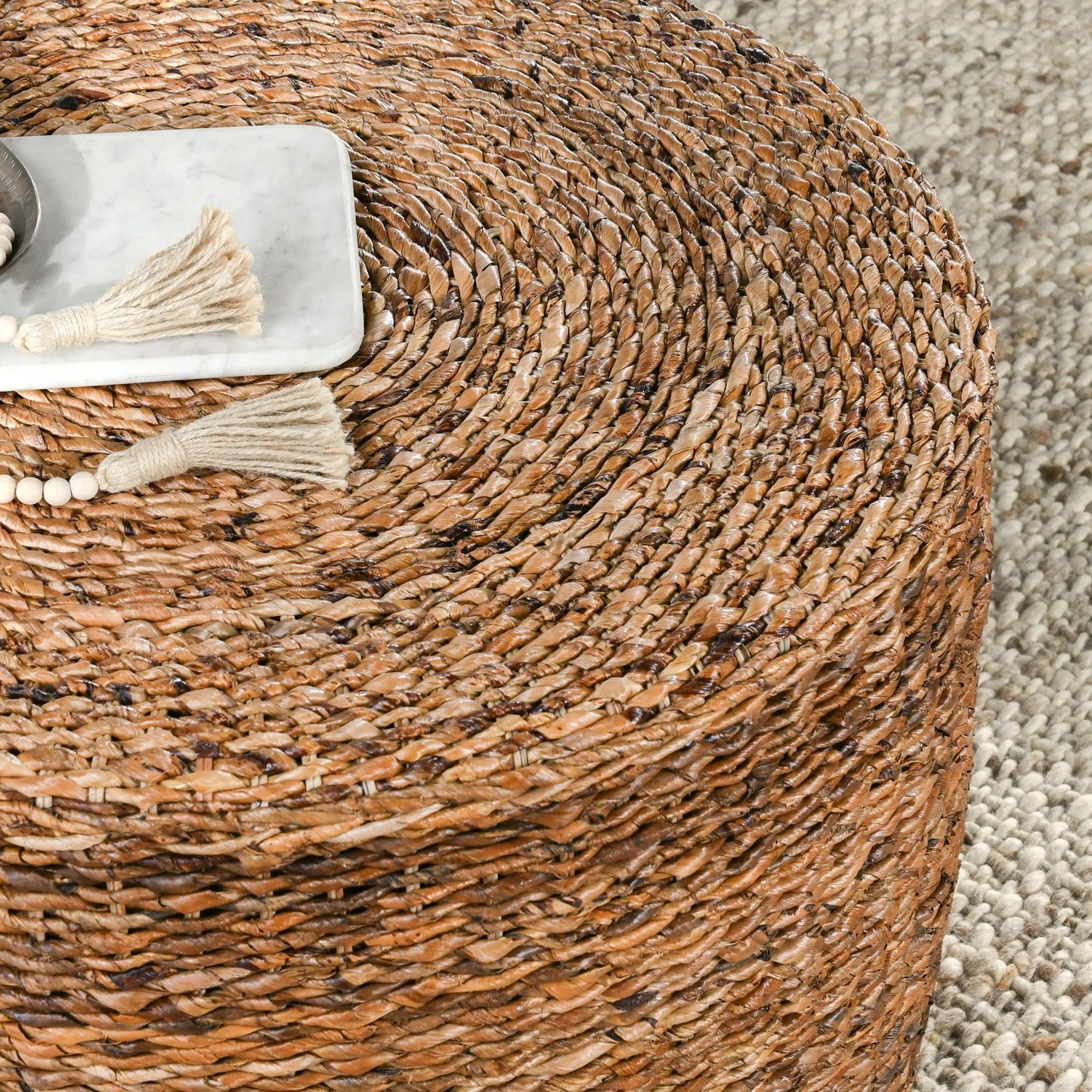 002 SR-897711 | Closeup | Ira Round Rattan Coffee Table by Kosas Home. Made from rattan abaca in a coastal style.
