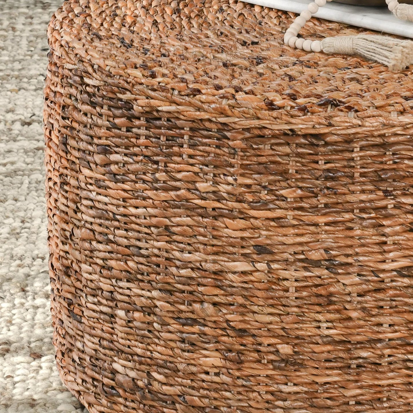 006 SR-897711 | Closeup | Ira Round Rattan Coffee Table by Kosas Home. Made from rattan abaca in a coastal style.