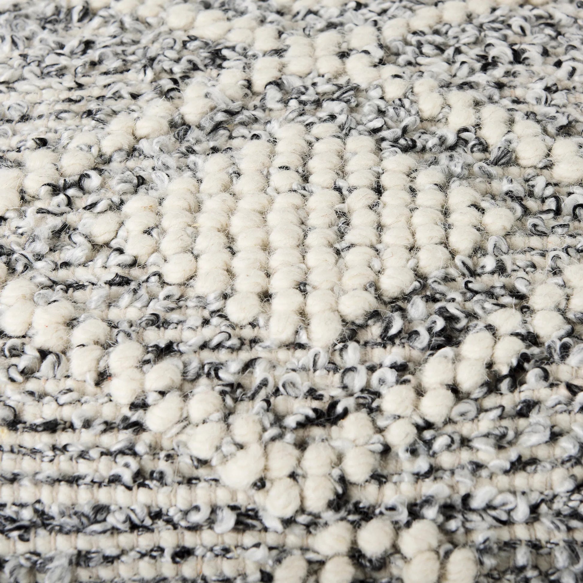 Ekiya Pouf by Mercana in gray, white. Made from wool in a rustic style.