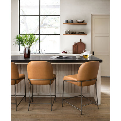 Astrud Bar Stool by Four Hands in sierra butterscotch. Made from faux leather, iron, top grain leather in a modern style.