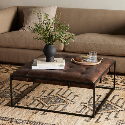 Oxford Square Coffee Table by Four Hands in rialto ebony, antique brass. Made from top grain leather, iron, 100% polyester in a modern style.