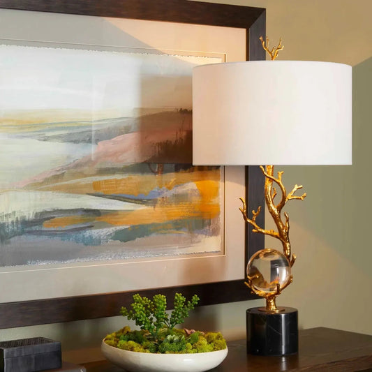 Autumnus Table Lamp by Cyan Design in gold leaf. Made from iron, crystal, marble with white linen shade in a transitional style.