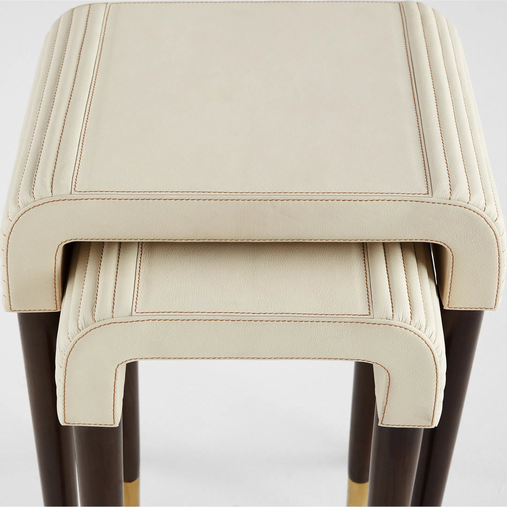 Channel Nesting Tables (Set of 2) by Cyan Design in off white, walnut. Made from leather, mdf, brass in a transitional style.