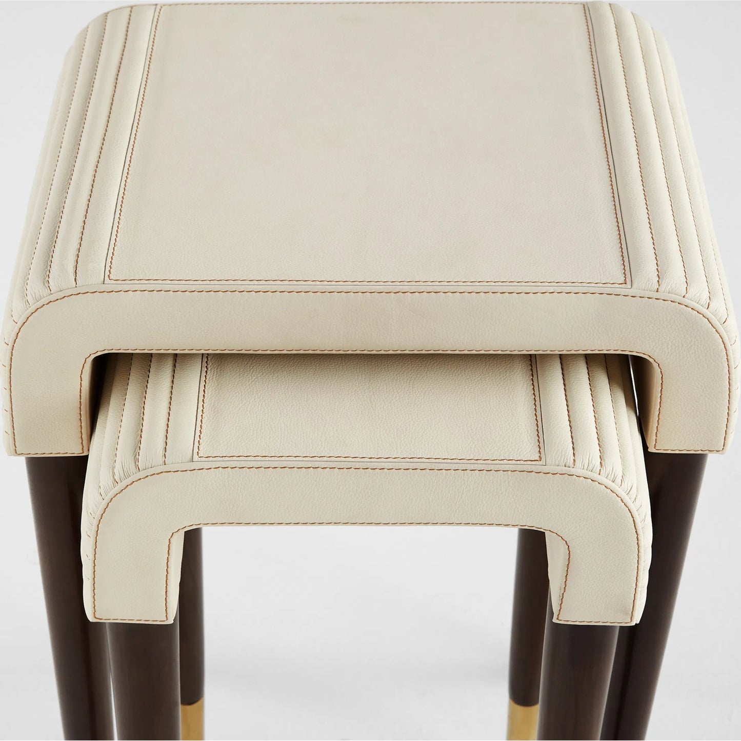 003 SI-2328575 | Closeup | Channel Nesting Tables (Set of 2) by Cyan Design in off white, walnut. Made from leather, mdf, brass in a transitional style.