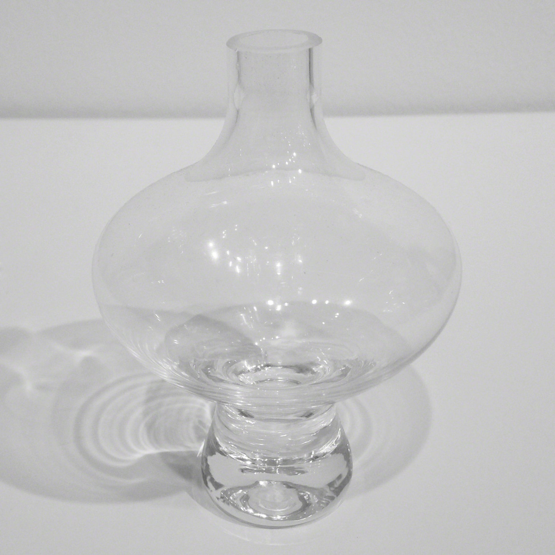 Mini Floating Footed Vase by Global Views. Made from glass in a modern style.