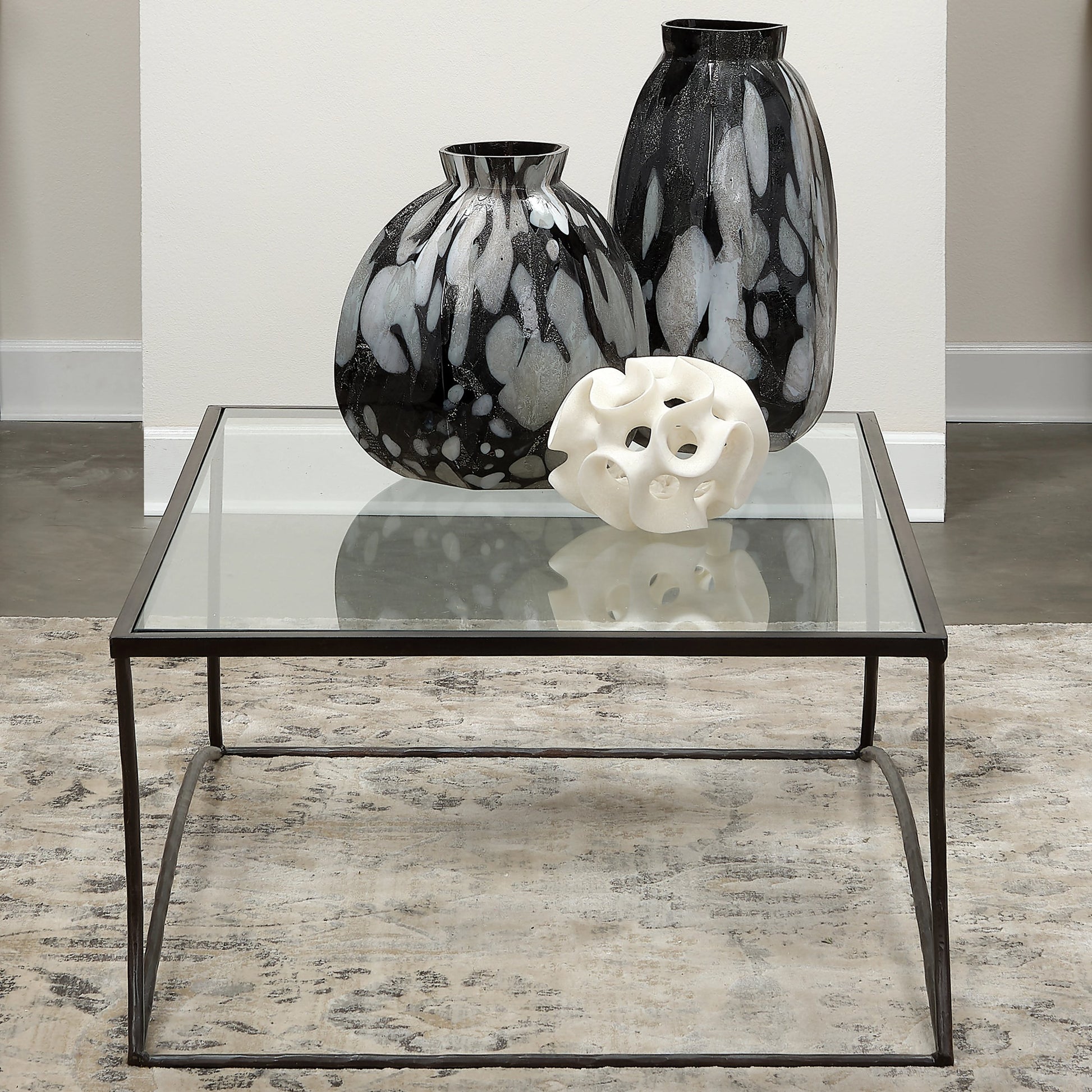 Kai Coffee Table by Jamie Young in black. Made from forged iron, clear tempered glass top in a modern style.