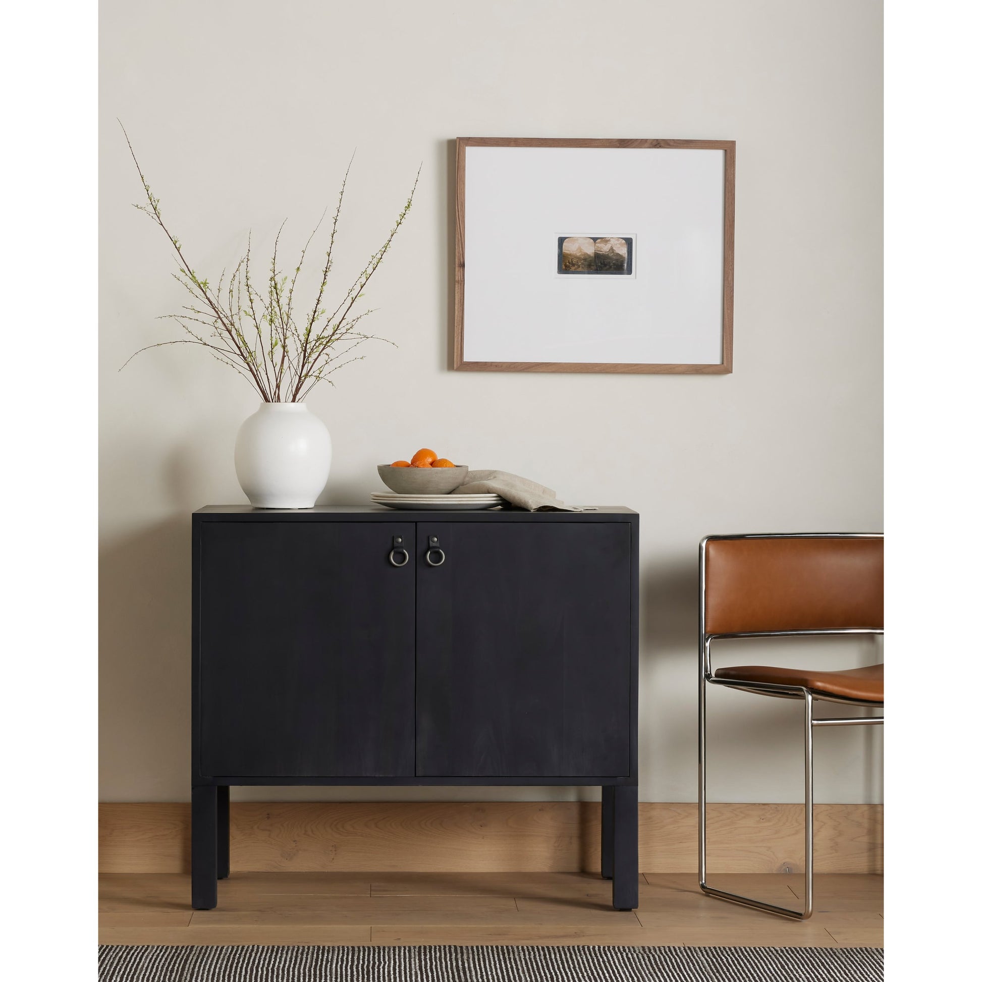 Isador Bar Cabinet by Four Hands in black wash poplar, natural iron, black leather and black wash poplar. Made from solid poplar, top grain leather in a modern style.
