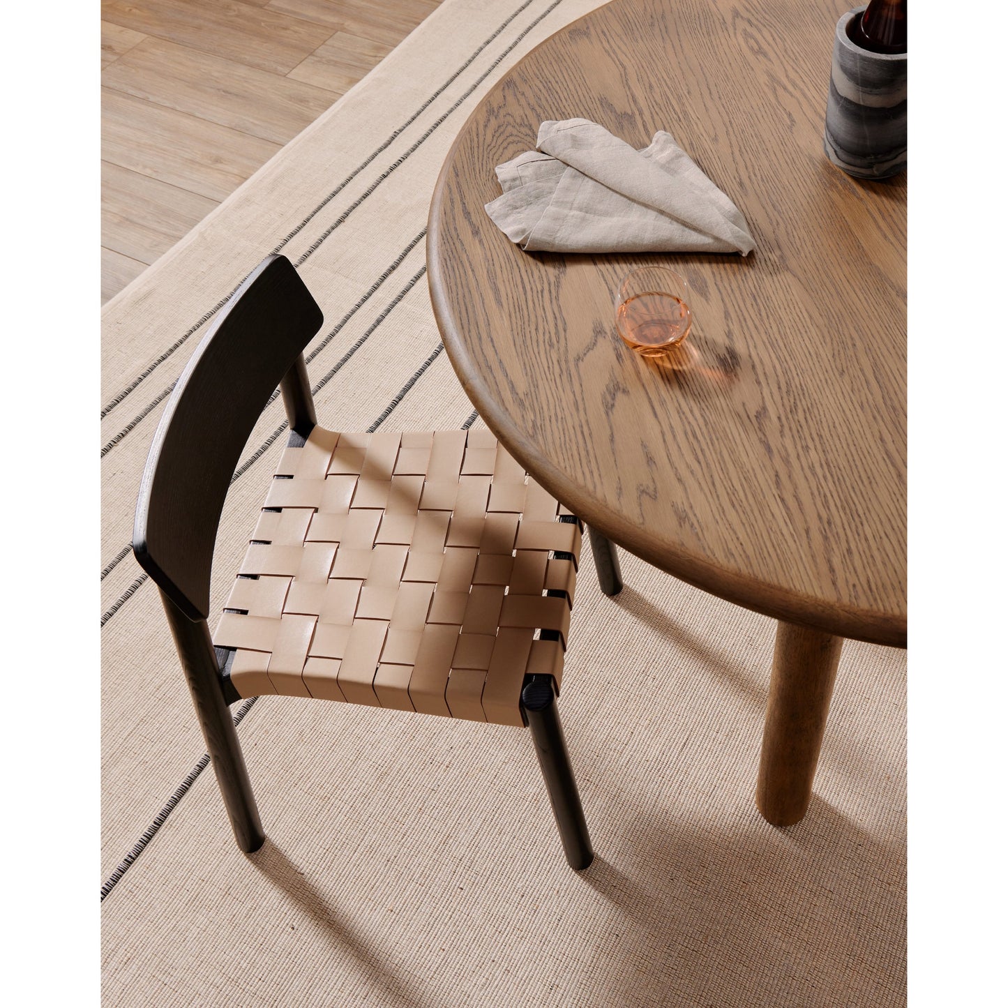 012 SI-1797666 | Lifestyle | Heisler Dining Chair by Four Hands in almond leather and black. Made from solid ash, 70% split leather, 30% polyvinyl chloride (pvc), ash veneer in a modern style.