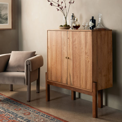 Reza Bar Cabinet by Four Hands in smoked honey parawood. Made from solid parawood, brass, solid acacia in a transitional style.
