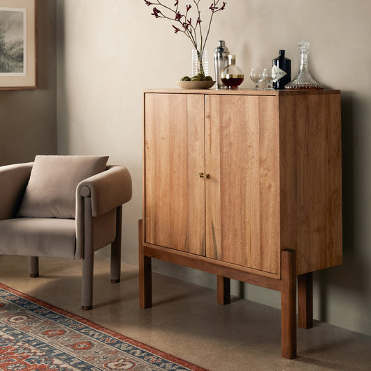 Reza Bar Cabinet by Four Hands in smoked honey parawood. Made from solid parawood, brass, solid acacia in a transitional style.