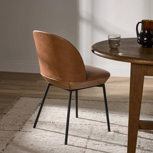 Imani Dining Chair by Four Hands in sonoma butterscotch and black iron. Made from top grain leather, iron, 100% polyester in a modern style.