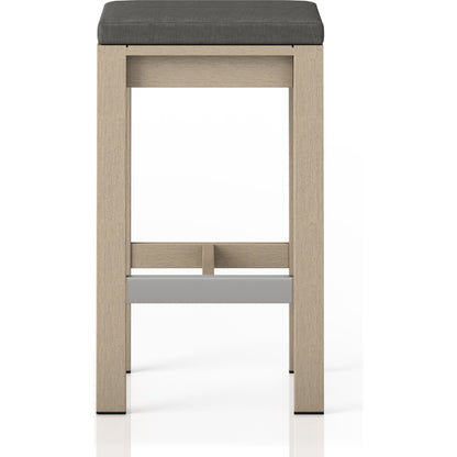 Monterey Bar Stool by Four Hands in faye navy and weathered grey. Made from 100% olefin, solid fsc®-certified teak, 91% polyurethane foam pad, 9% polyester fiber batting in a modern style.