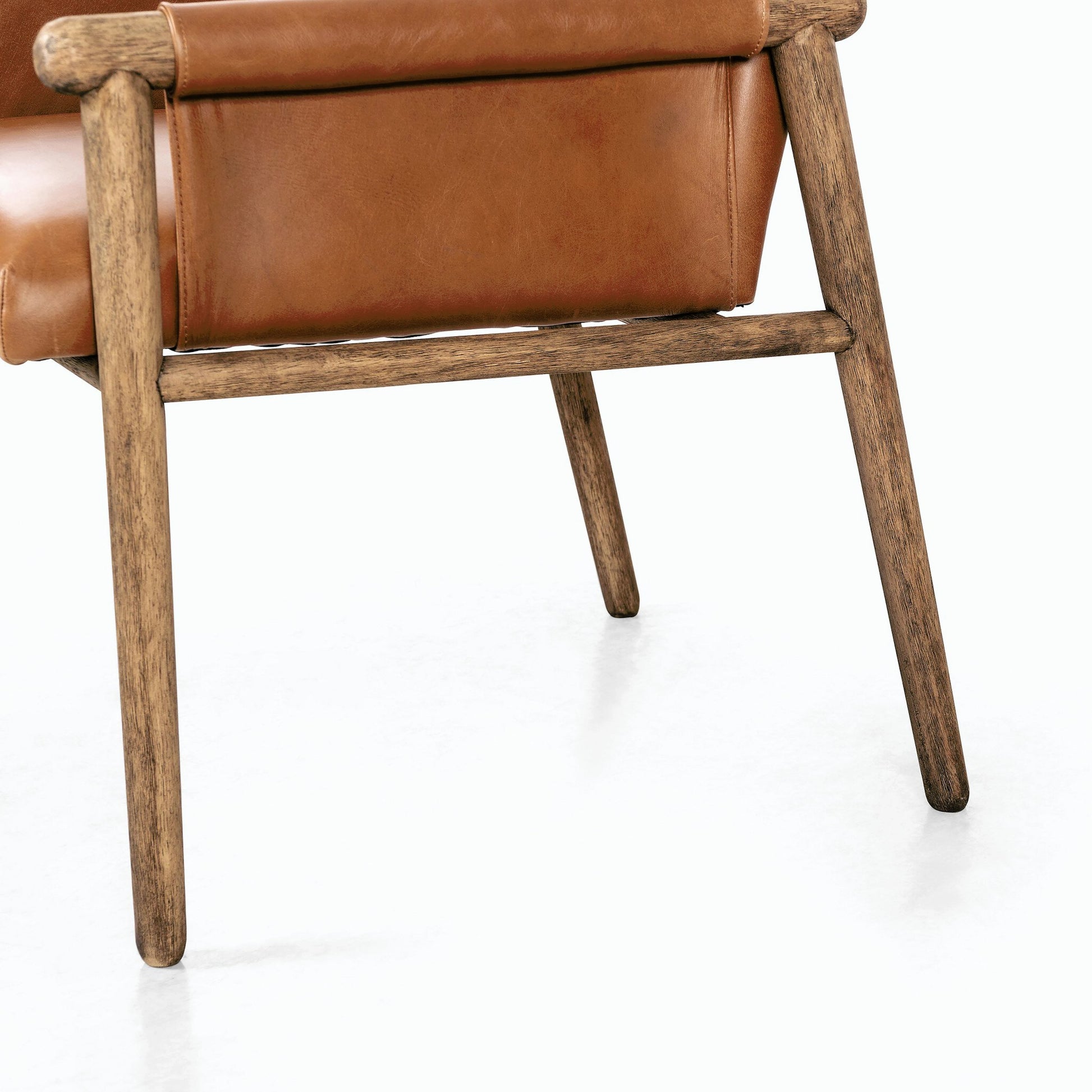 Almada Dining Armchair by Four Hands in valencia camel, distressed natural. Made from top grain leather, solid parawood, 100% polyester in a transitional style.