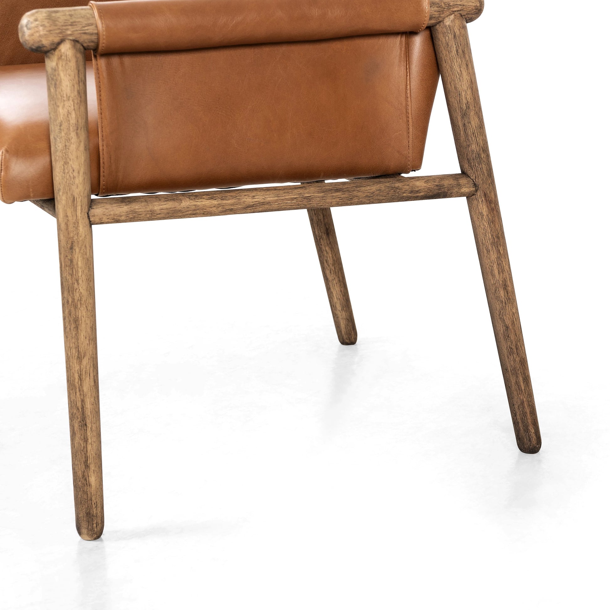 Almada Dining Armchair by Four Hands in valencia camel, distressed natural. Made from top grain leather, solid parawood, 100% polyester in a transitional style.