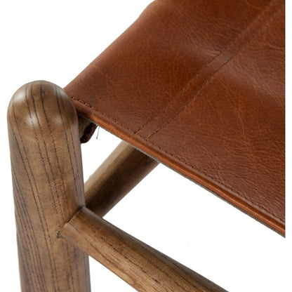 Nino Ottoman by Four Hands in dakota tobacco. Made from top grain leather, solid nettlewood, 100% polyester in a modern style.