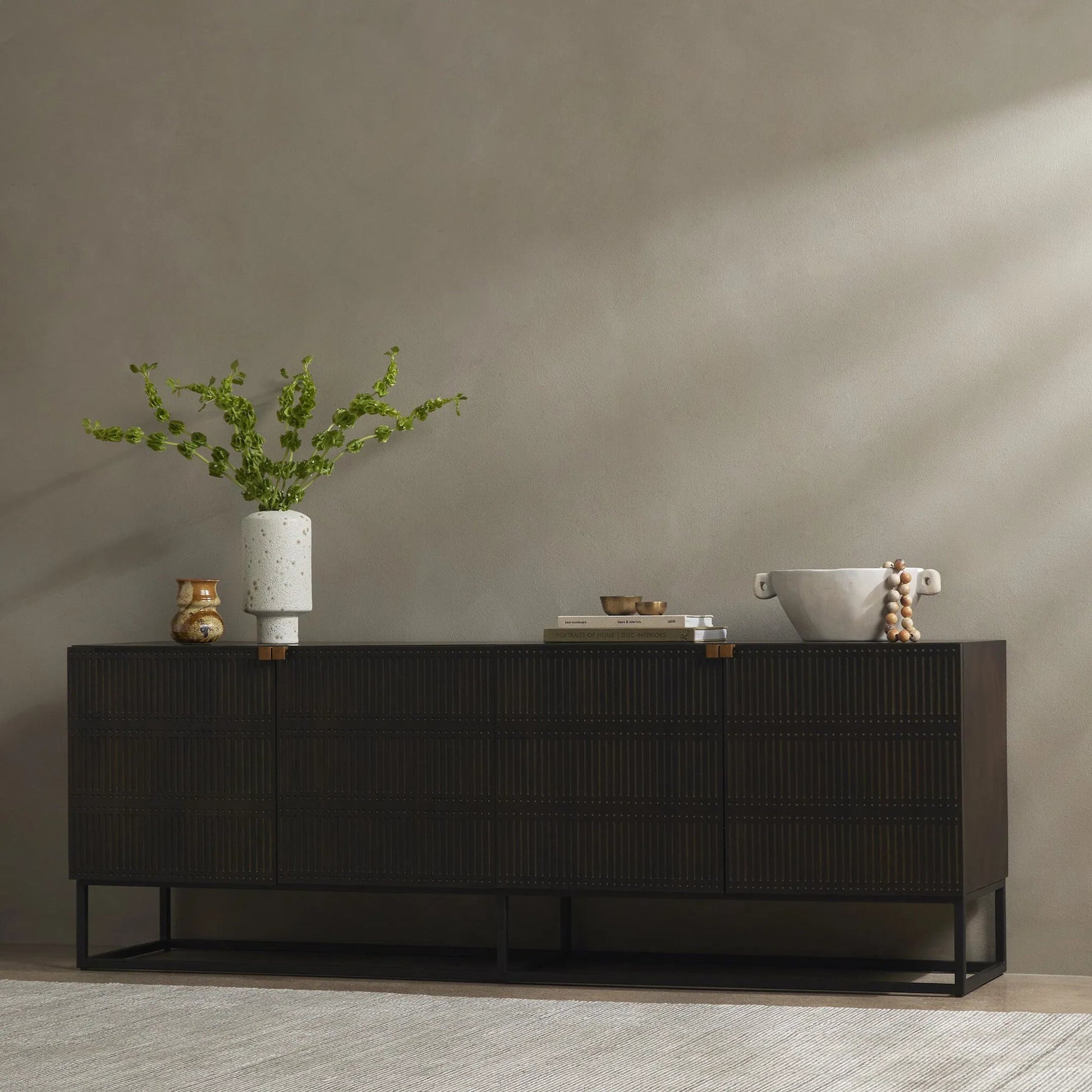 Kelby Closed Media Console by Four Hands in aged brass, carved vintage brown, vintage brown, gunmetal. Made from solid mango, iron in a modern style.