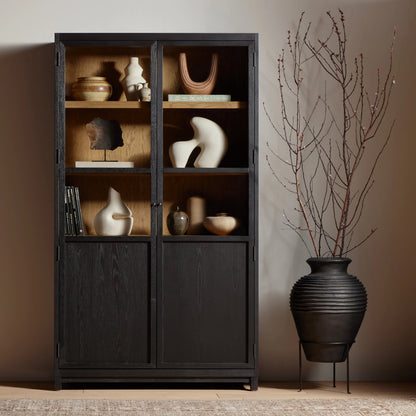 Millie Panel & Glass Door Cabinet by Four Hands in drifted matte black. Made from solid oak, oak veneer in a modern style.