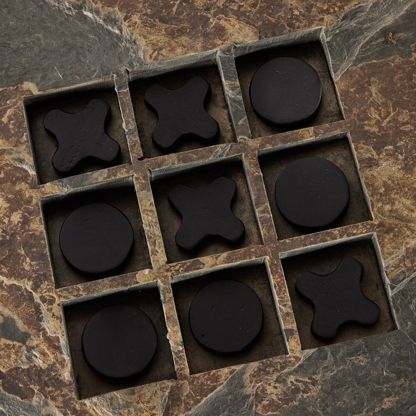 005 SI-2001964 | Closeup | Stone Tic Tac Toe by Four Hands in grey stone, aged metal, carbonized black. Made from slate flagstone solid, solid mixed reclaimed wood, iron in a rustic style.