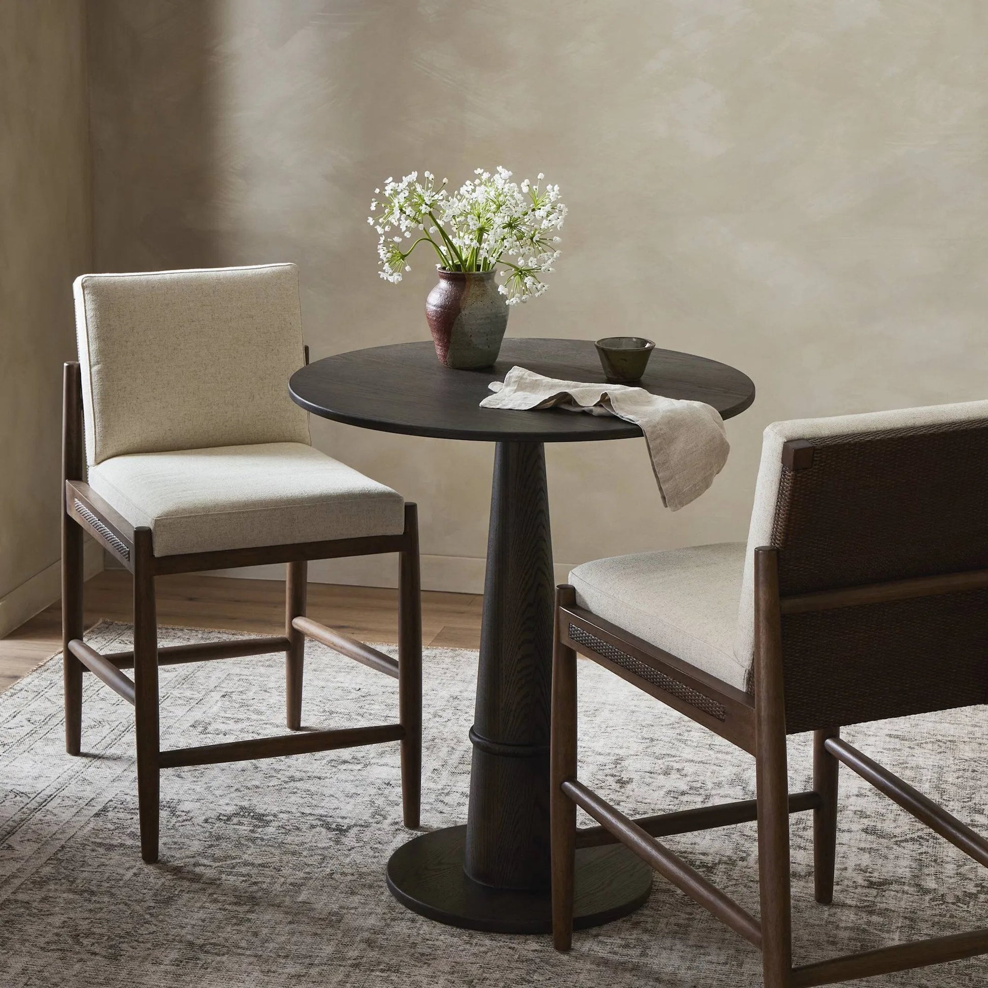 Costera Bar Stool by Four Hands in antwerp natural, almond, vintage cross woven cane. Made from 39% linen, 35% cotton, 26% polyester, solid parawood, cane in a traditional style.