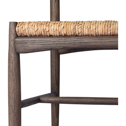 Jovan Dining Chair by Four Hands in stained saddle brown, slight dark bleaching. Made from solid oak, banana leaf in a traditional style.