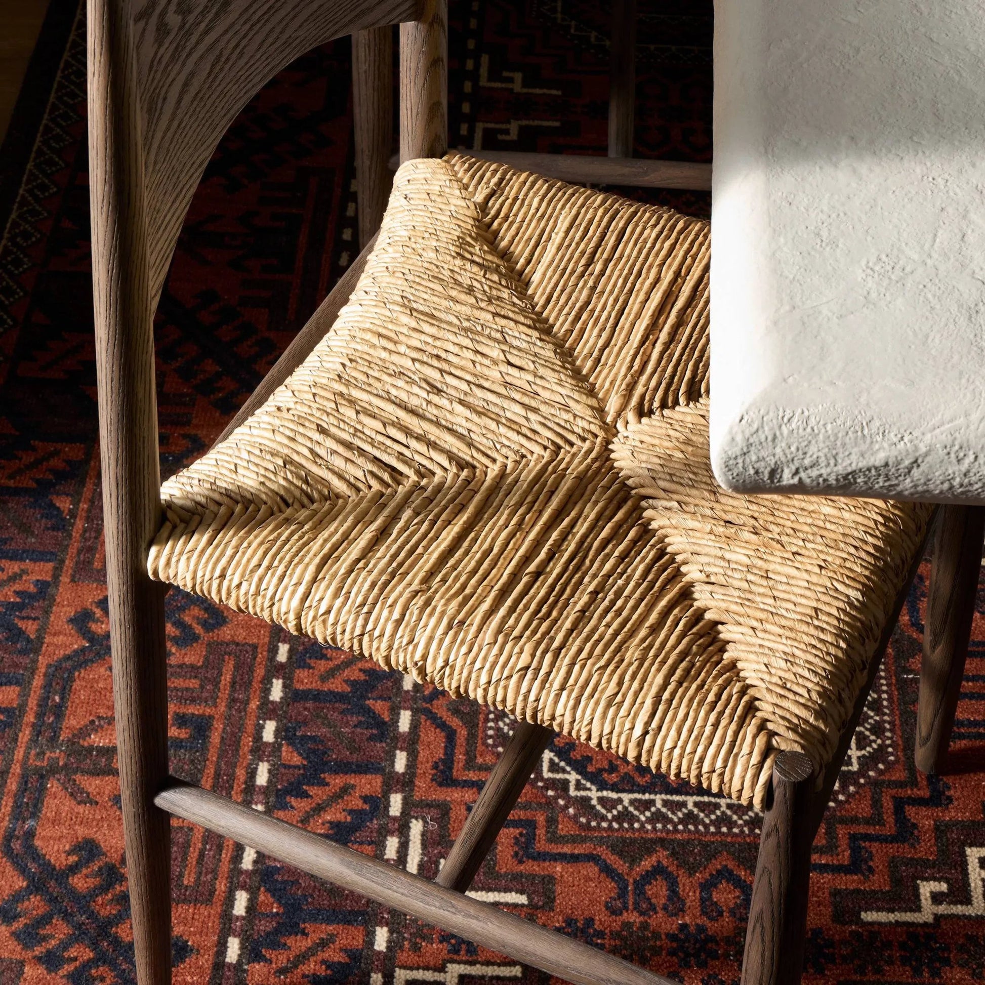 Jovan Dining Chair by Four Hands in stained saddle brown, slight dark bleaching. Made from solid oak, banana leaf in a traditional style.