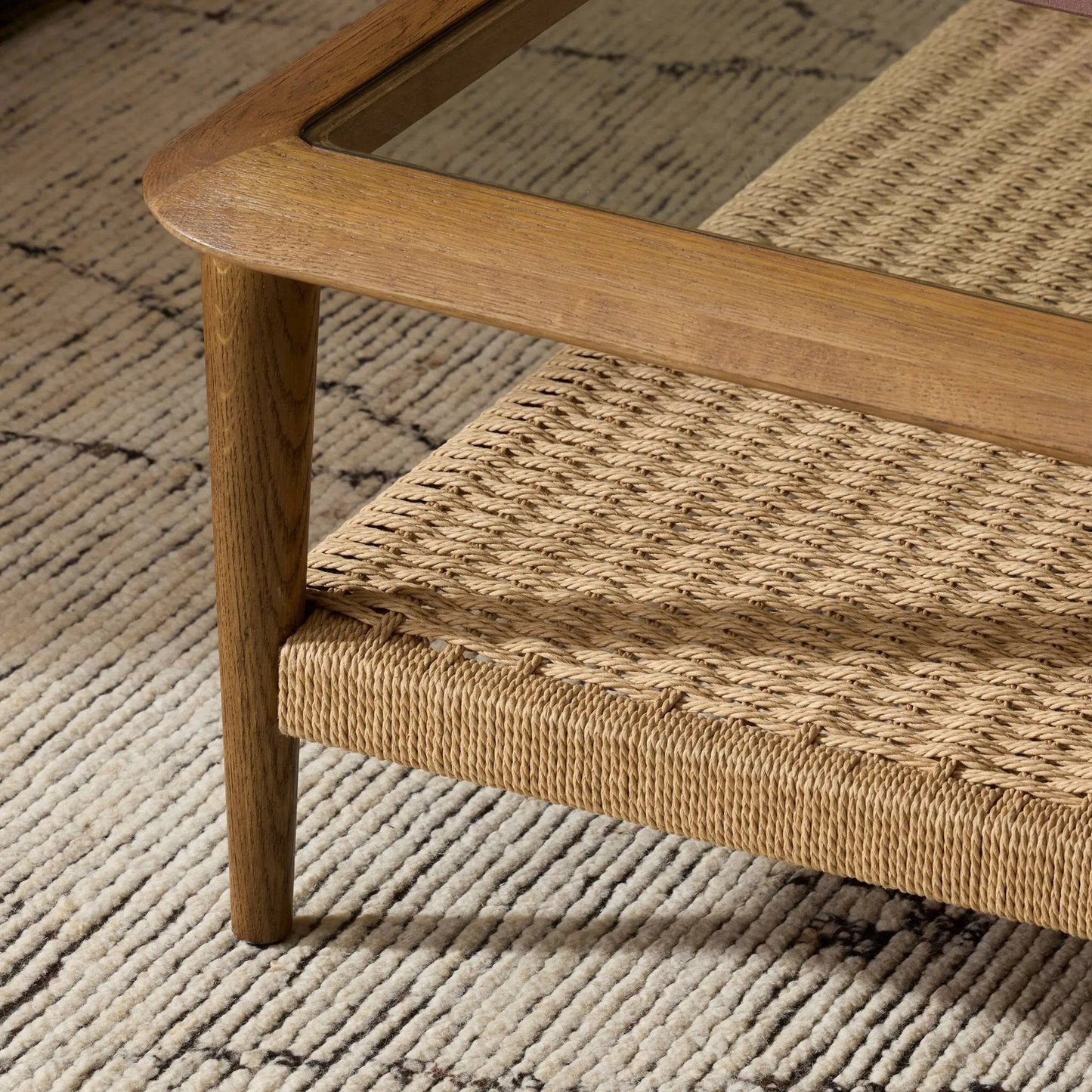 009 SI-2446532 | Closeup | Carmelo Coffee Table by Four Hands in tempered glass, natural paper cord, medium brown oak. Made from tempered glass, rush, solid oak in a transitional style.