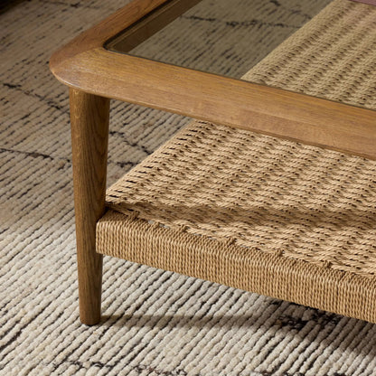 Carmelo Coffee Table by Four Hands in tempered glass, natural paper cord, medium brown oak. Made from tempered glass, rush, solid oak in a transitional style.