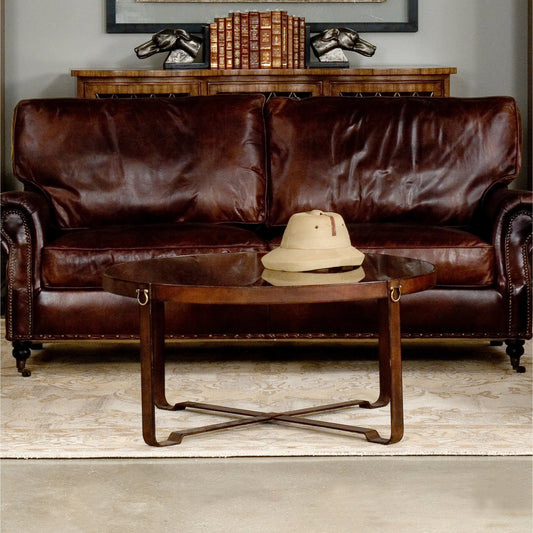 Harness Round Coffee Table by Sarreid Ltd. in brown, clear and smoke glass; brass handles. Made from leather, glass, iron in a modern style.