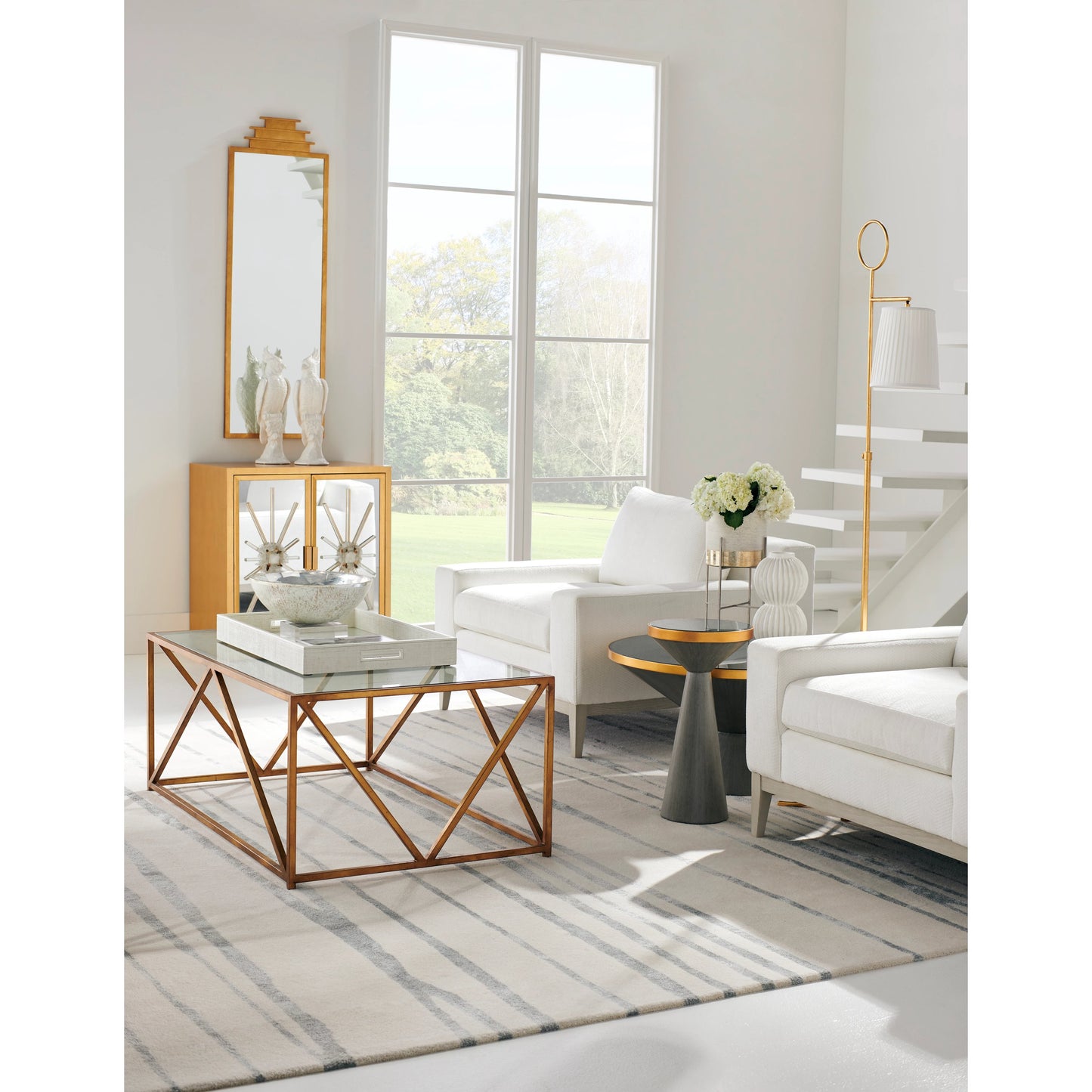006 SR-383346 | Lifestyle | N Y Cocktail Table by Chelsea House in gray wash, antique gold, dark gray. Made from glass in a modern style.